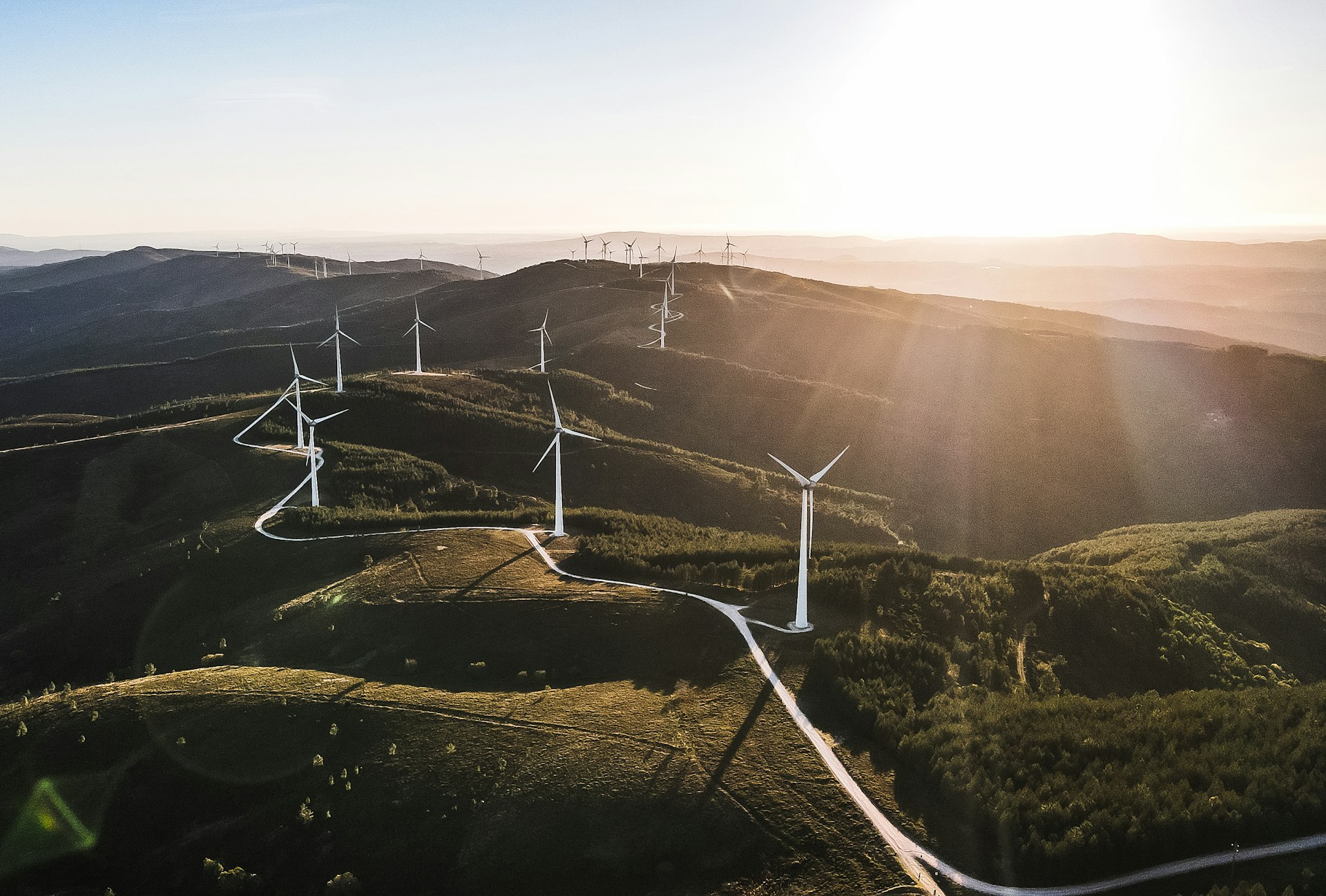 White wind turbines on green hills in a rural area of Spain